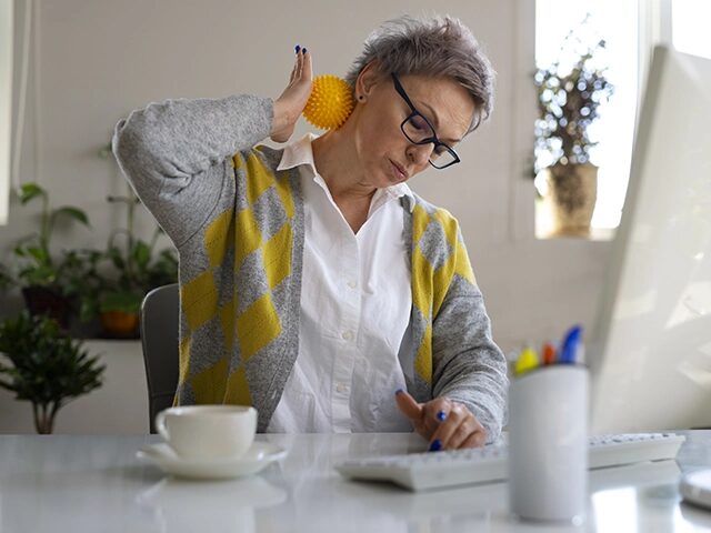 Femme qui se masse la nuque au travail